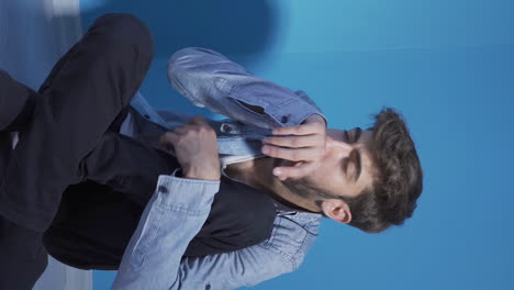 Vertical-video-of-Sick-man-coughing-leaning-against-wall.-Hopeless.